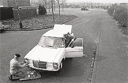 Bewoners repareren auto, 1986, fotograaf Baart
